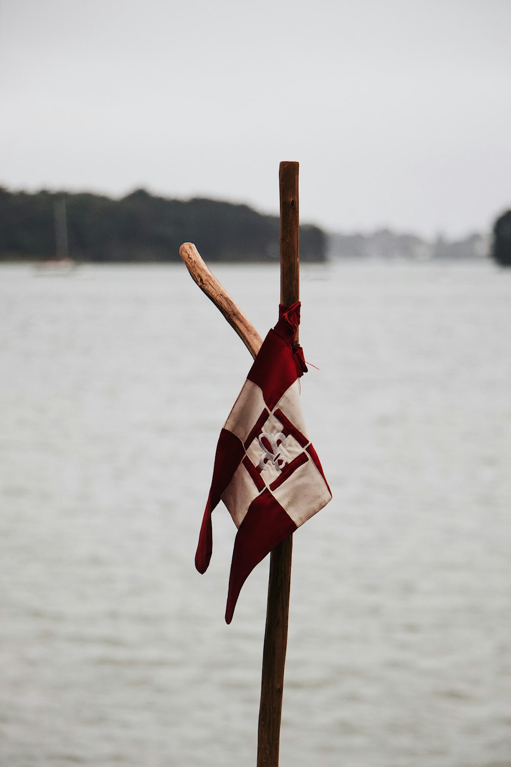 white and red flag on brown wooden pole