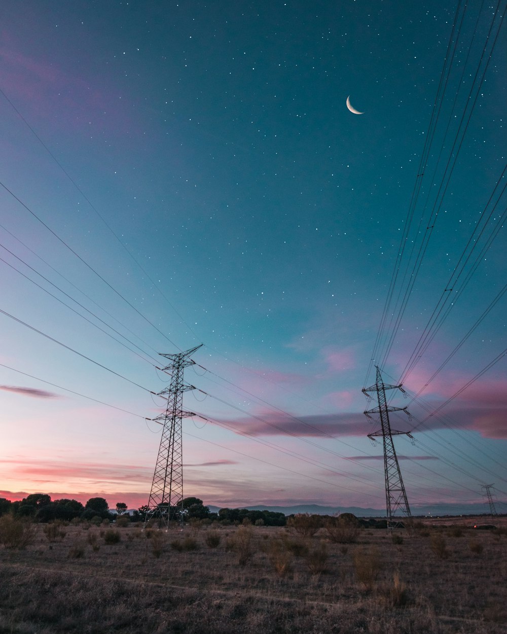 black transmission towers under clear night sky
