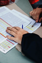 person's hand on two stack of paper