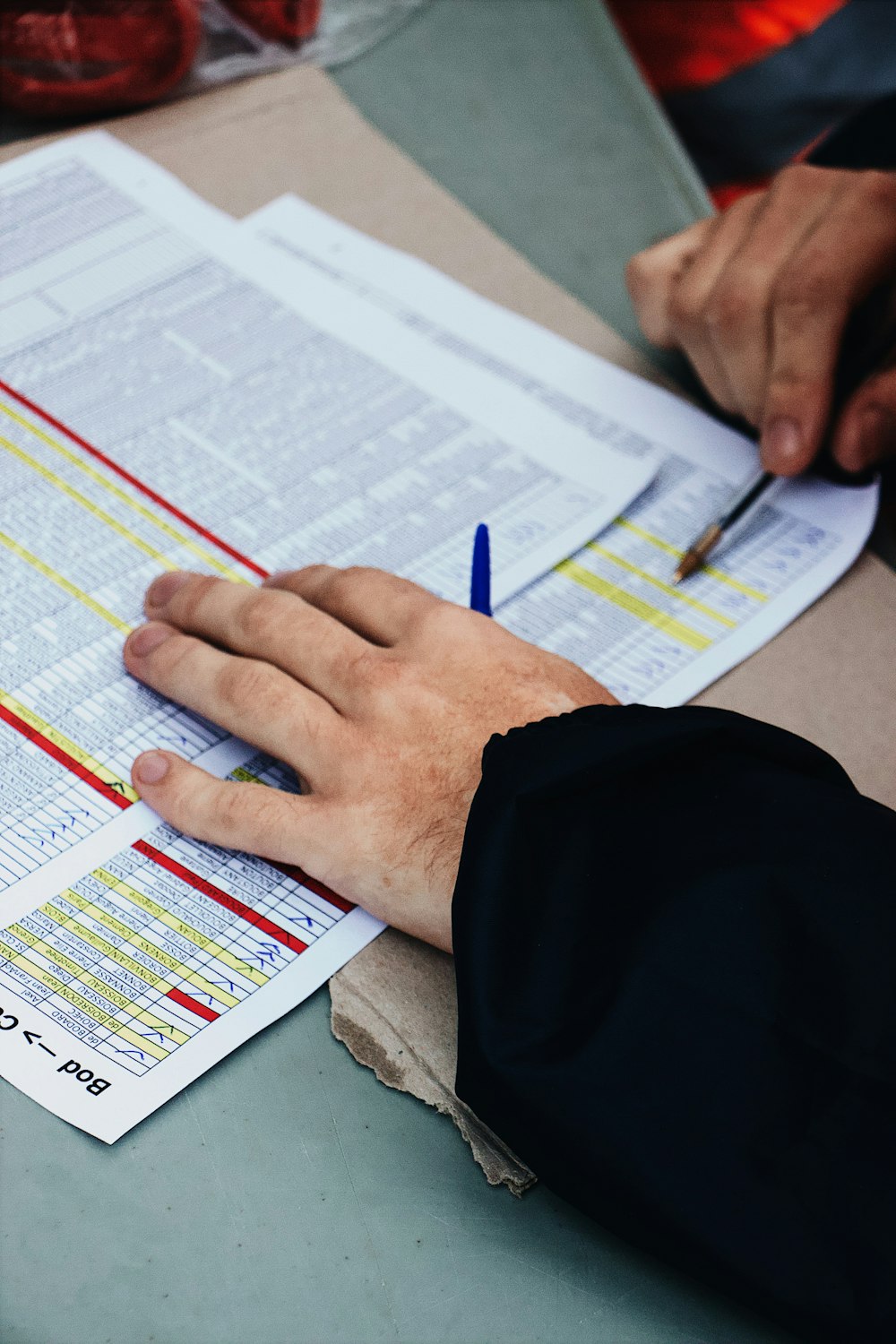 person's hand on two stack of paper