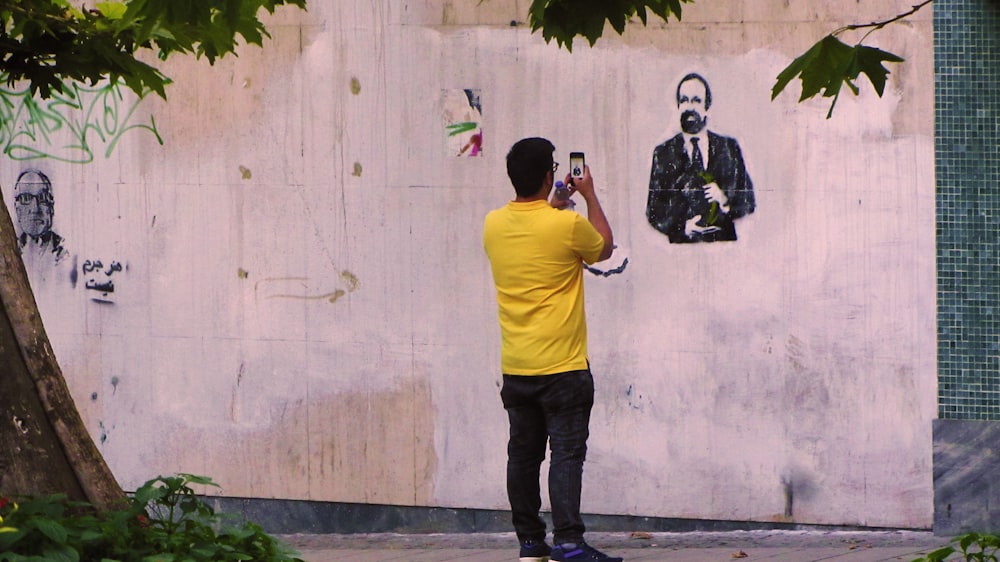 man taking picture of another man wearing black suit jacket graffiti