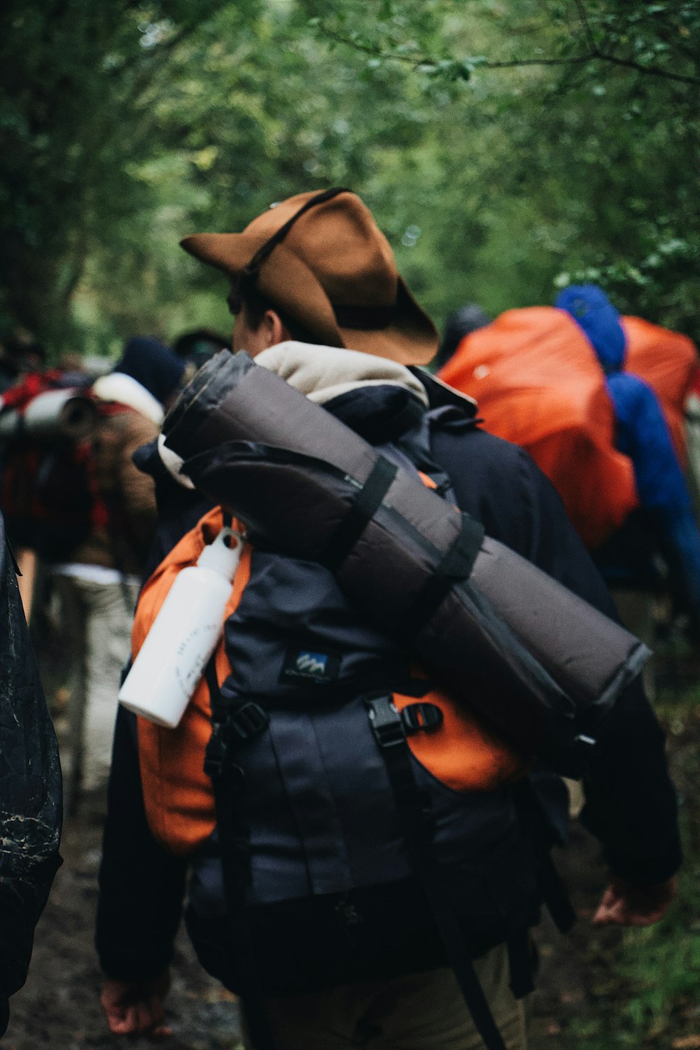 Mann trägt schwarzen Schlafsack und Rucksack