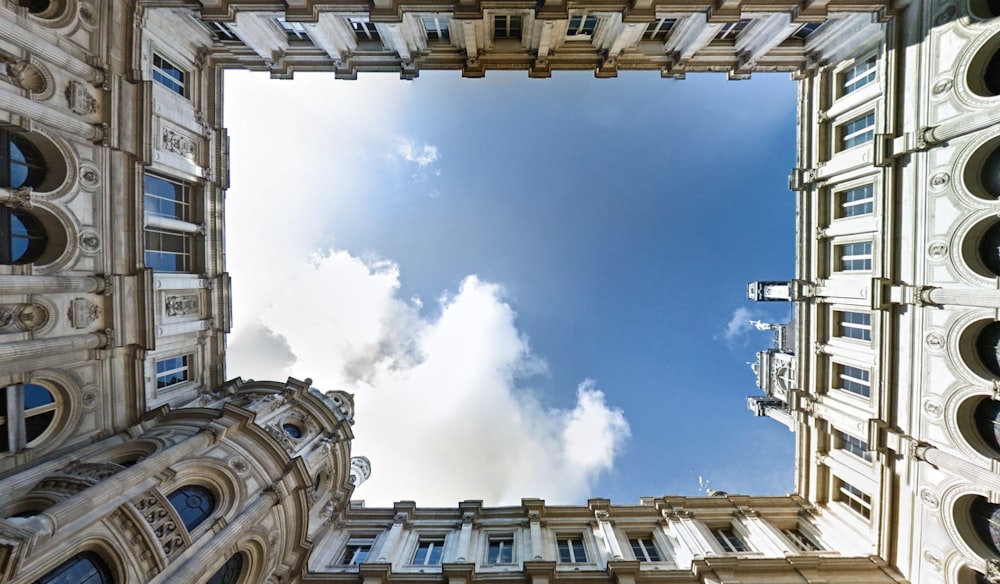 brown building under white clouds and blue sky