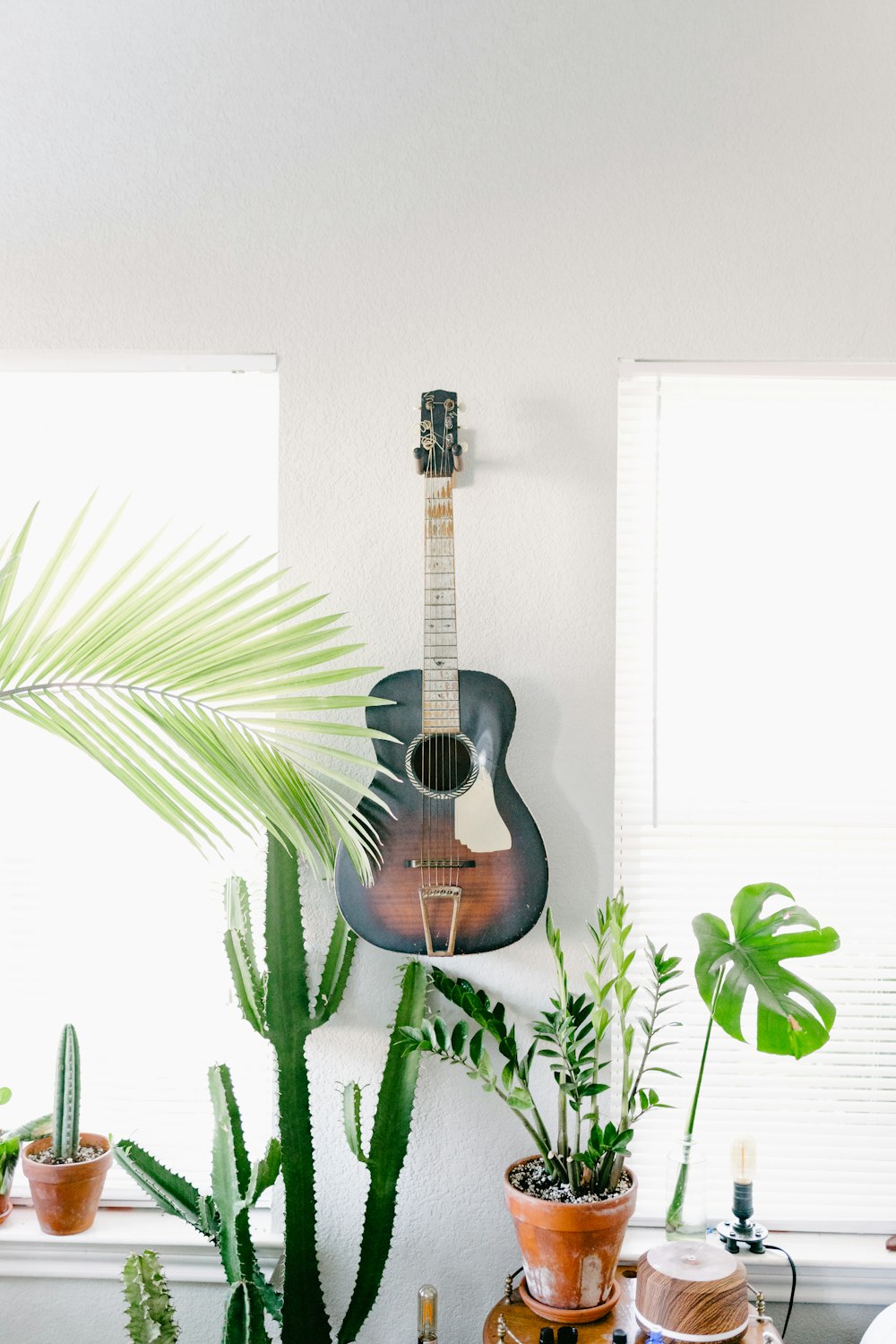 black and brown acoustic guitar hanging on wall