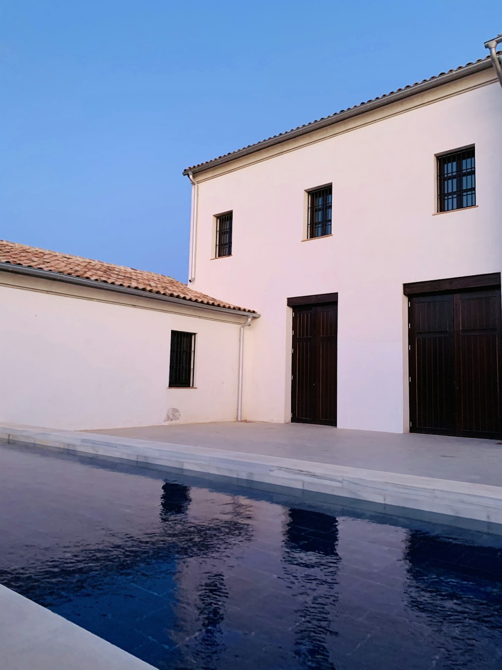 white and brown house with swimming pool