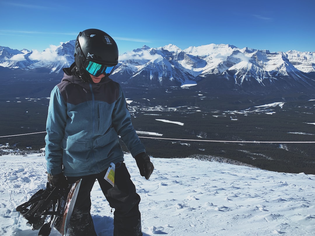 person on snow-capped mountain wearing helmet and snow goggles
