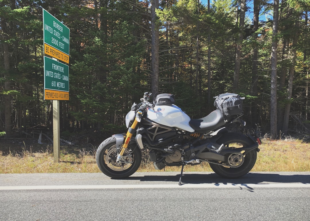 parked gray motorcycle beside road signs during daytime