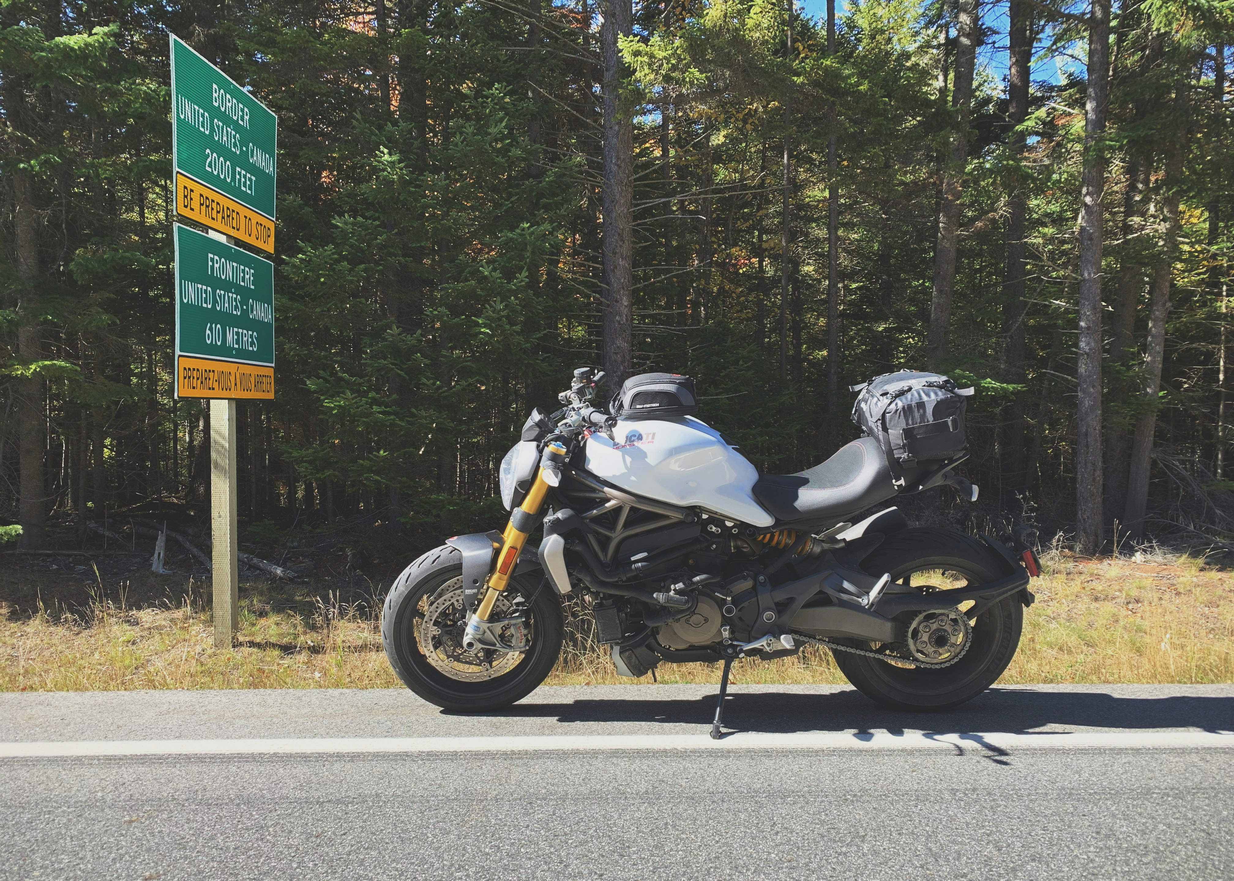 parked gray motorcycle beside road signs during daytime