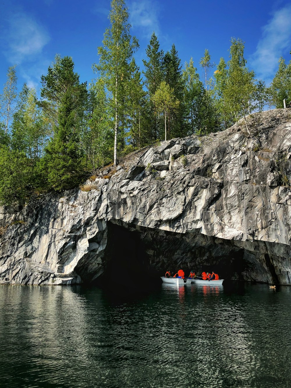 Personnes sur un bateau à côté d’une falaise