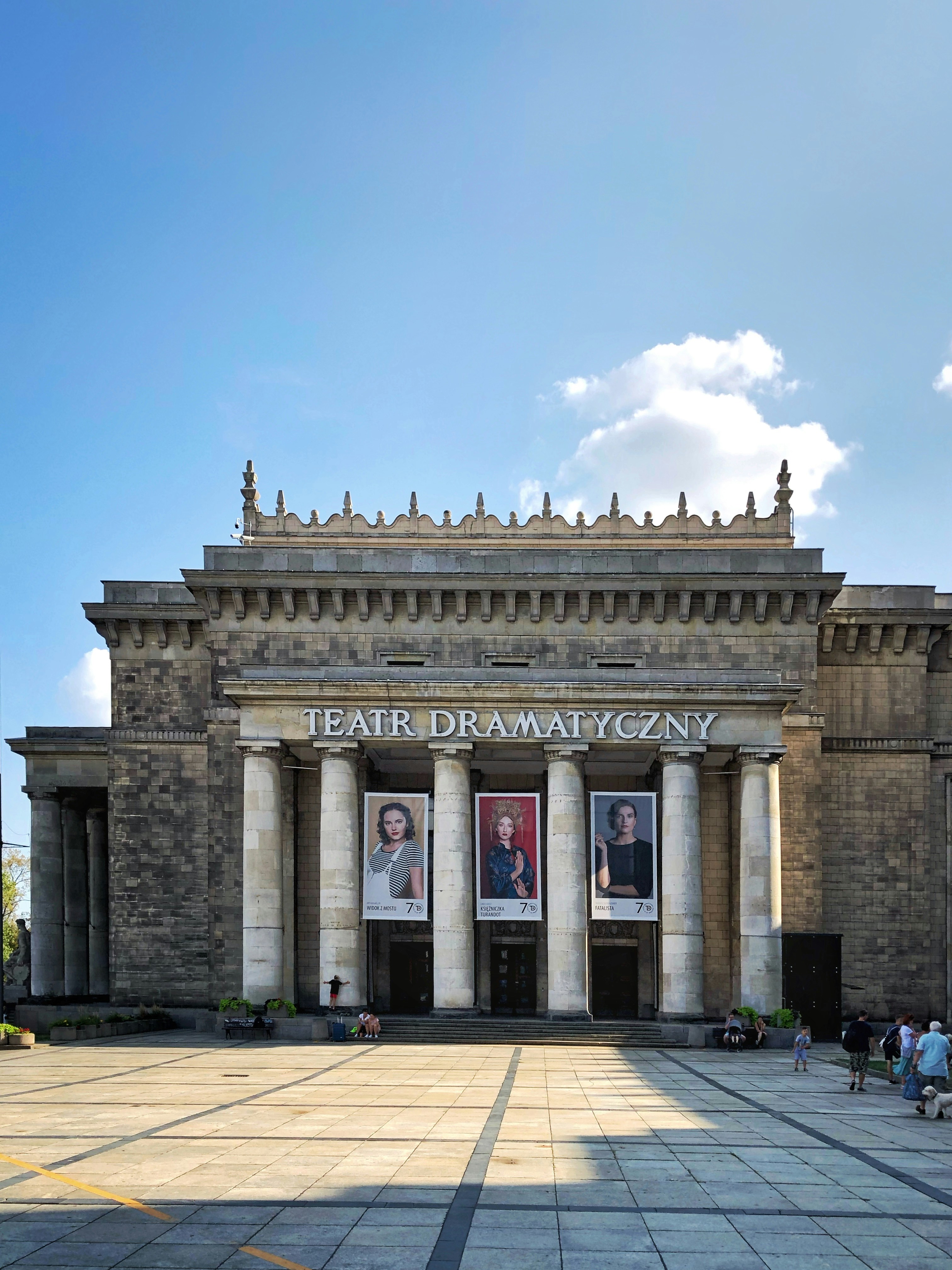 persone che camminano vicino a un edificio in cemento