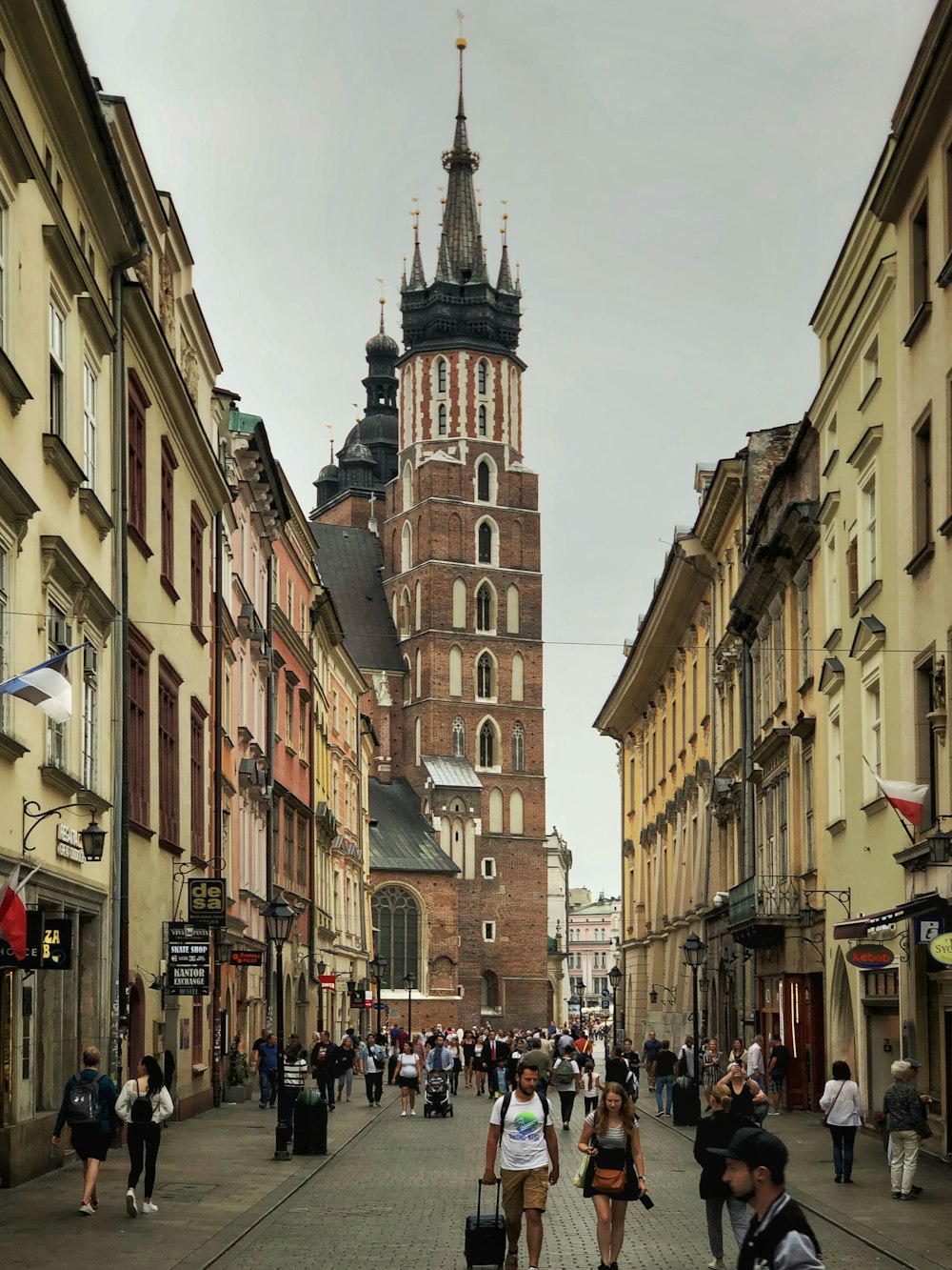 people walking on street between concrete structures