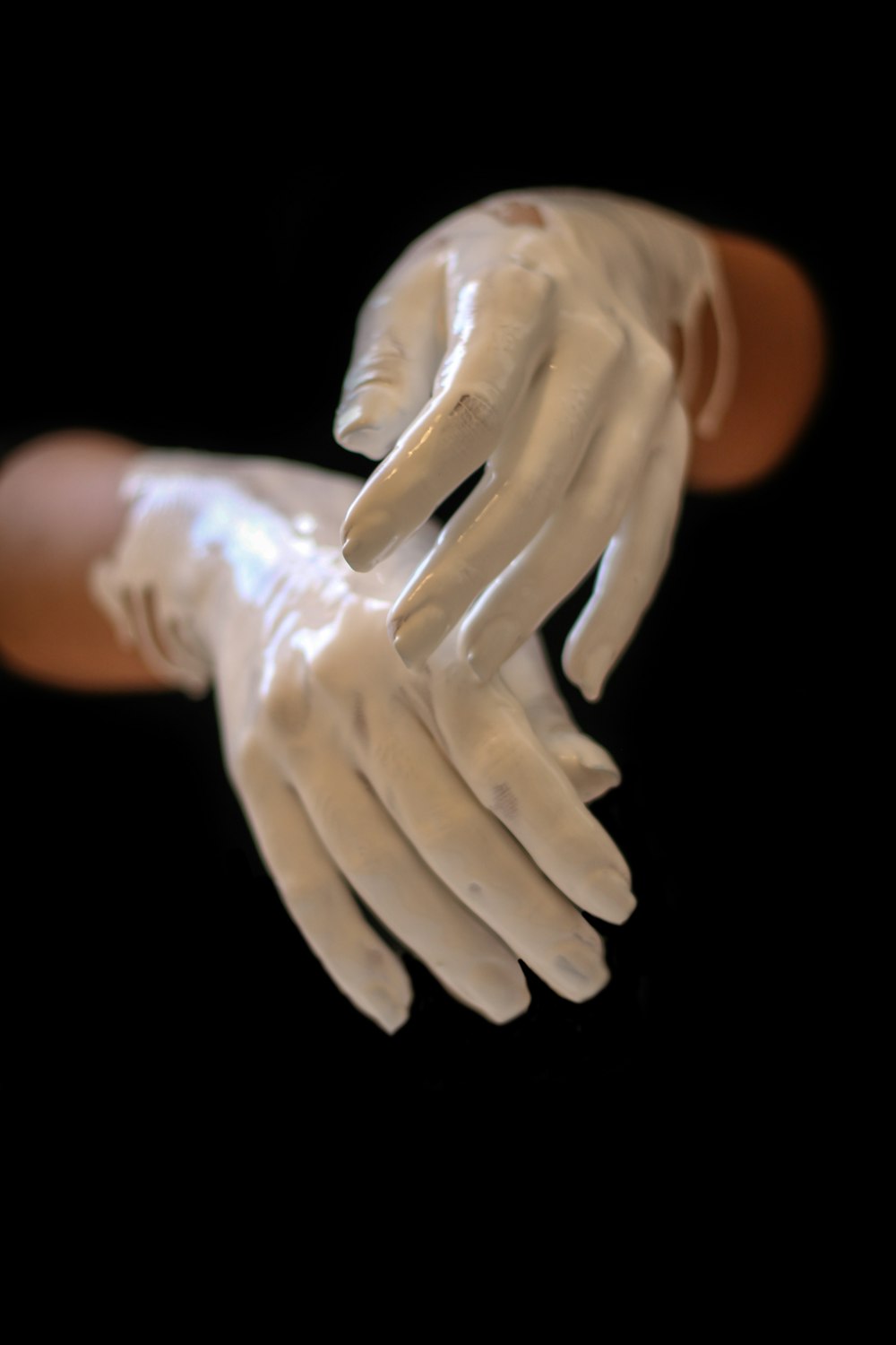 person's hands with white paint