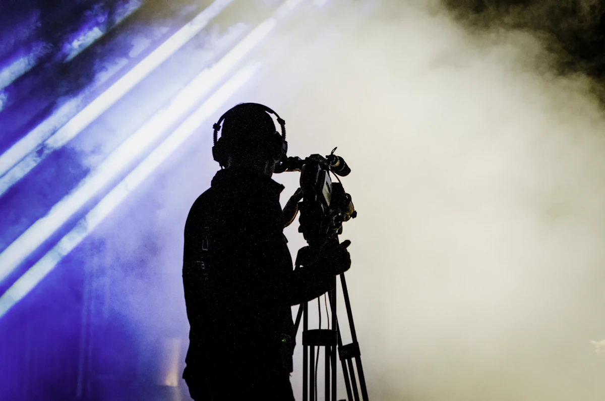 Camera operator on a tripod in stage smoke