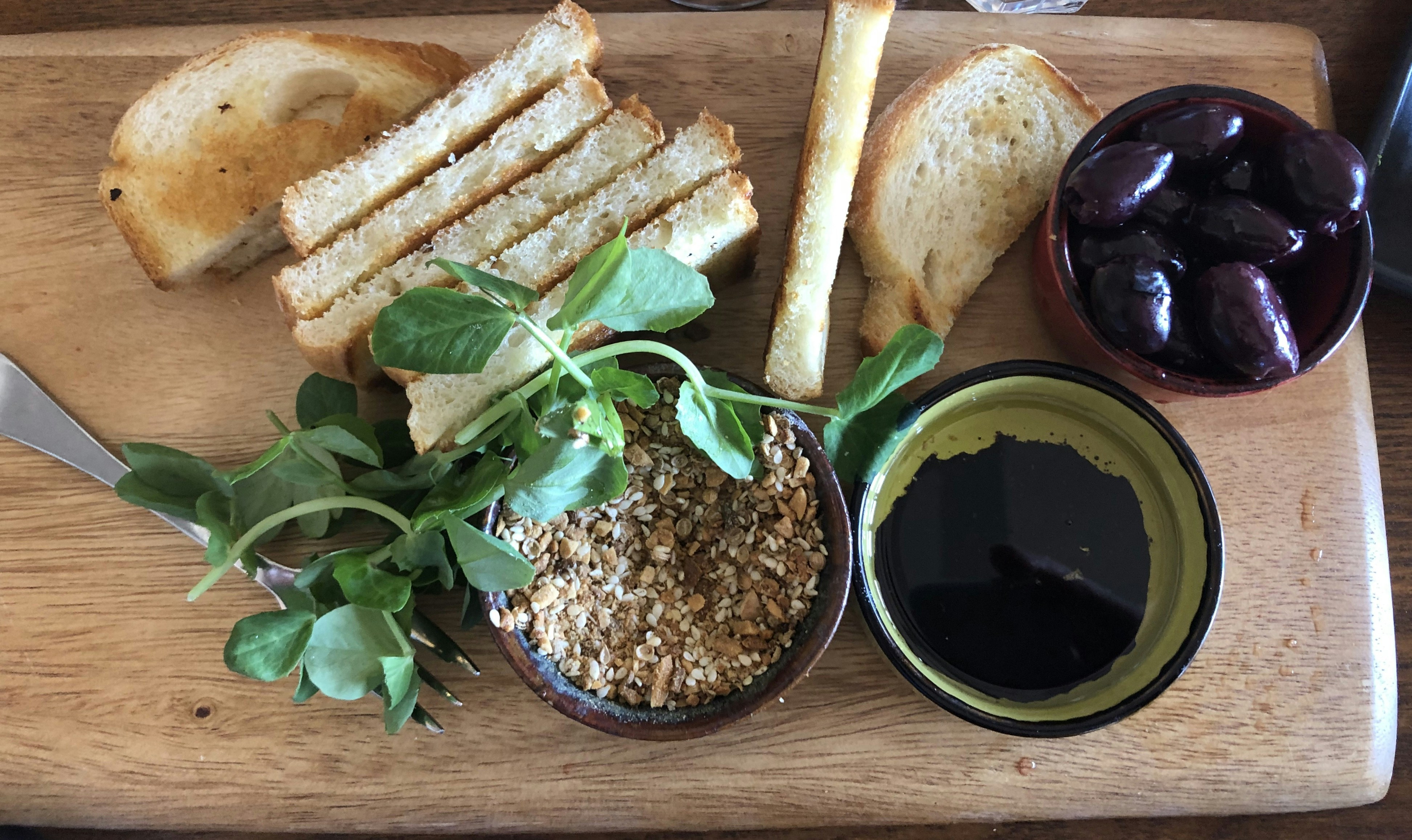 Tapenade d'olives noires dans un bol avec pain grillé et olives fraîches