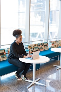 A focused student working on a tablet in a bright, modern space.