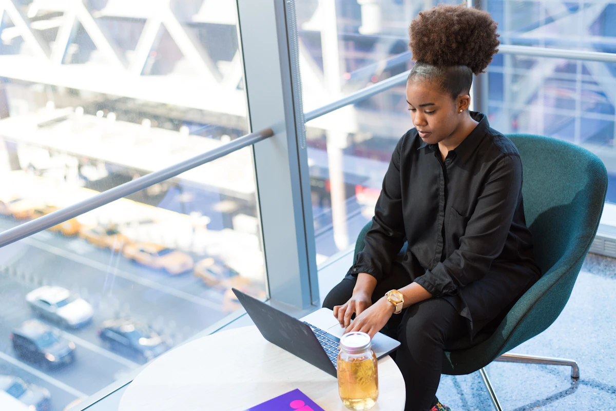 Woman in black dress shirt using MacBook