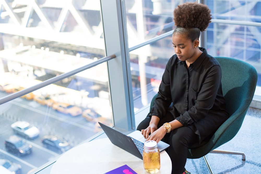 woman in black dress shirt using MacBook