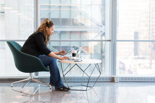 A consultant writing professional content on a laptop in a modern office.