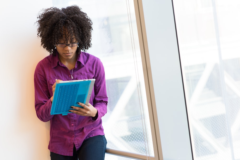 woman in purple dress shirt using laptop