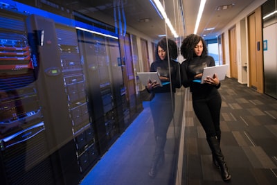 woman in black top using macbook technology teams background