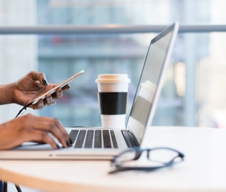 person using smartphone and MacBook