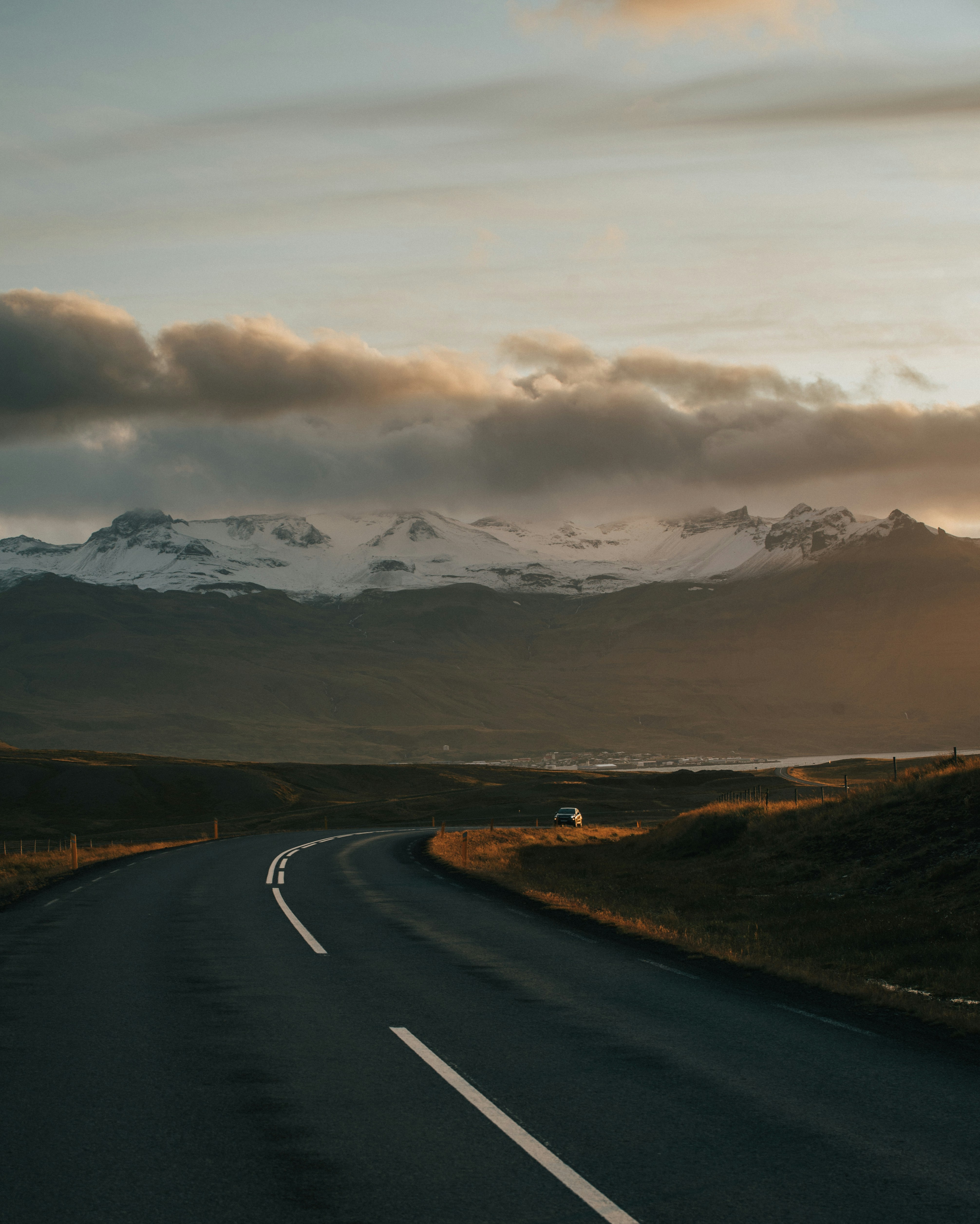 concrete road between grass fields