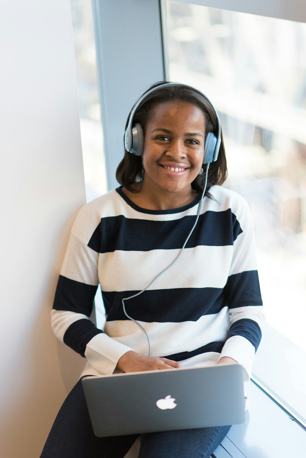 woman in white and black striped sweater using MacBook