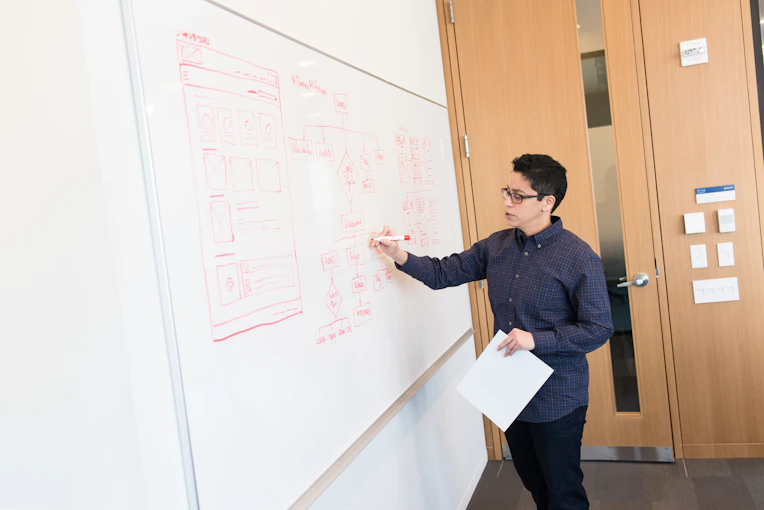 A confident professional standing in front of a digital whiteboard, explaining AI-driven project strategies.