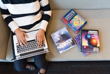 person in white and black striped top using MacBook