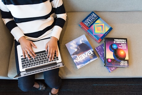 person in white and black striped top using MacBook