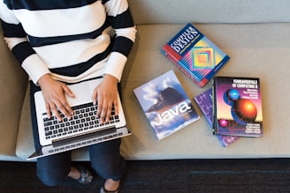 person in white and black striped top using MacBook