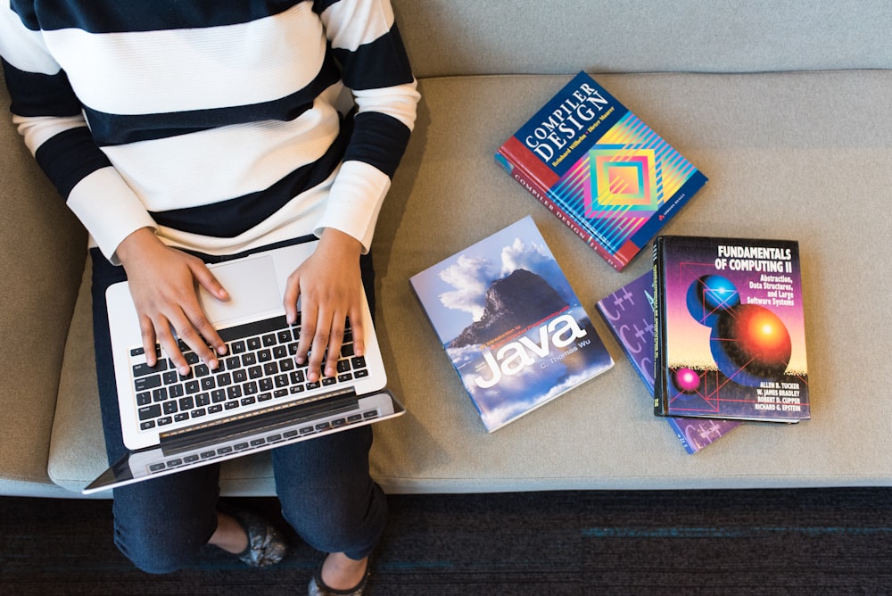 person in white and black striped top using MacBook