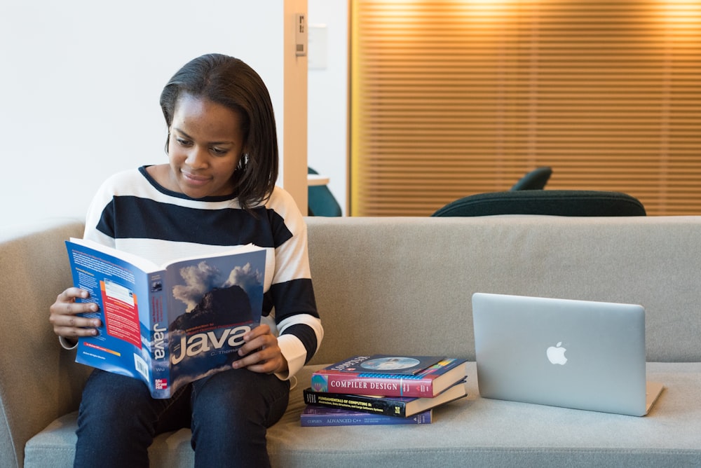 woman reading Java book on sofa