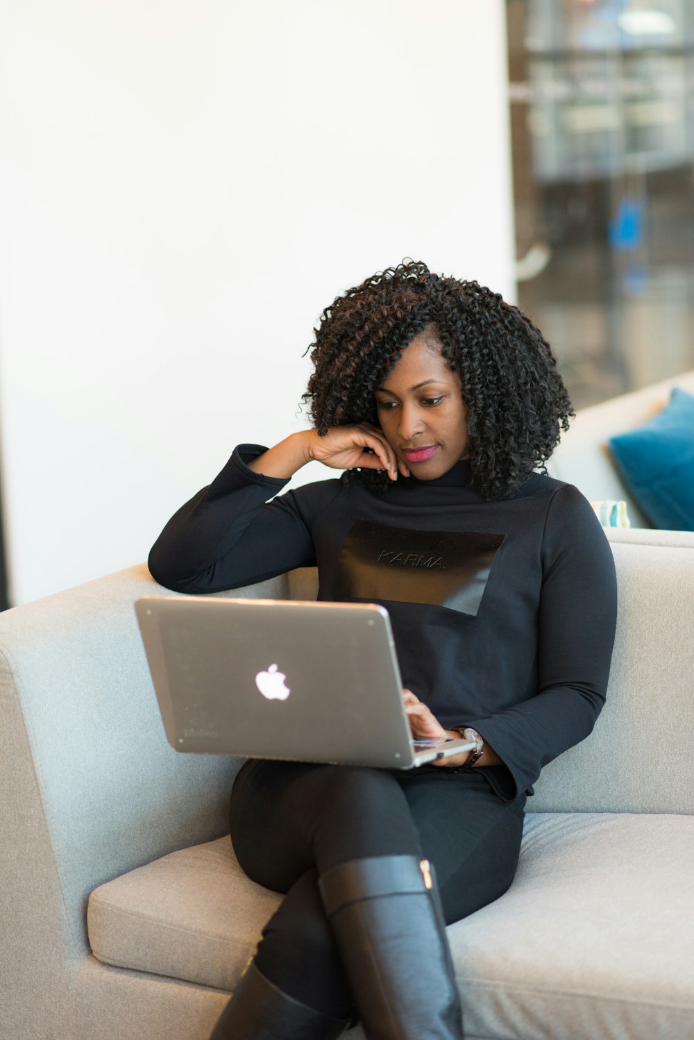Frau im schwarzen Mantel mit MacBook