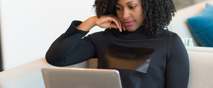 woman in black coat using MacBook