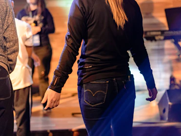 A warm, candid photo of a diverse group of young worship leaders and audio engineers collaborating on stage setup.