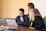 three women beside table looking at MacBook