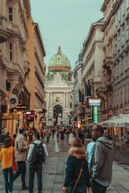 people walking between two buildings during daytime