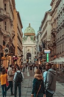 people walking between two buildings during daytime