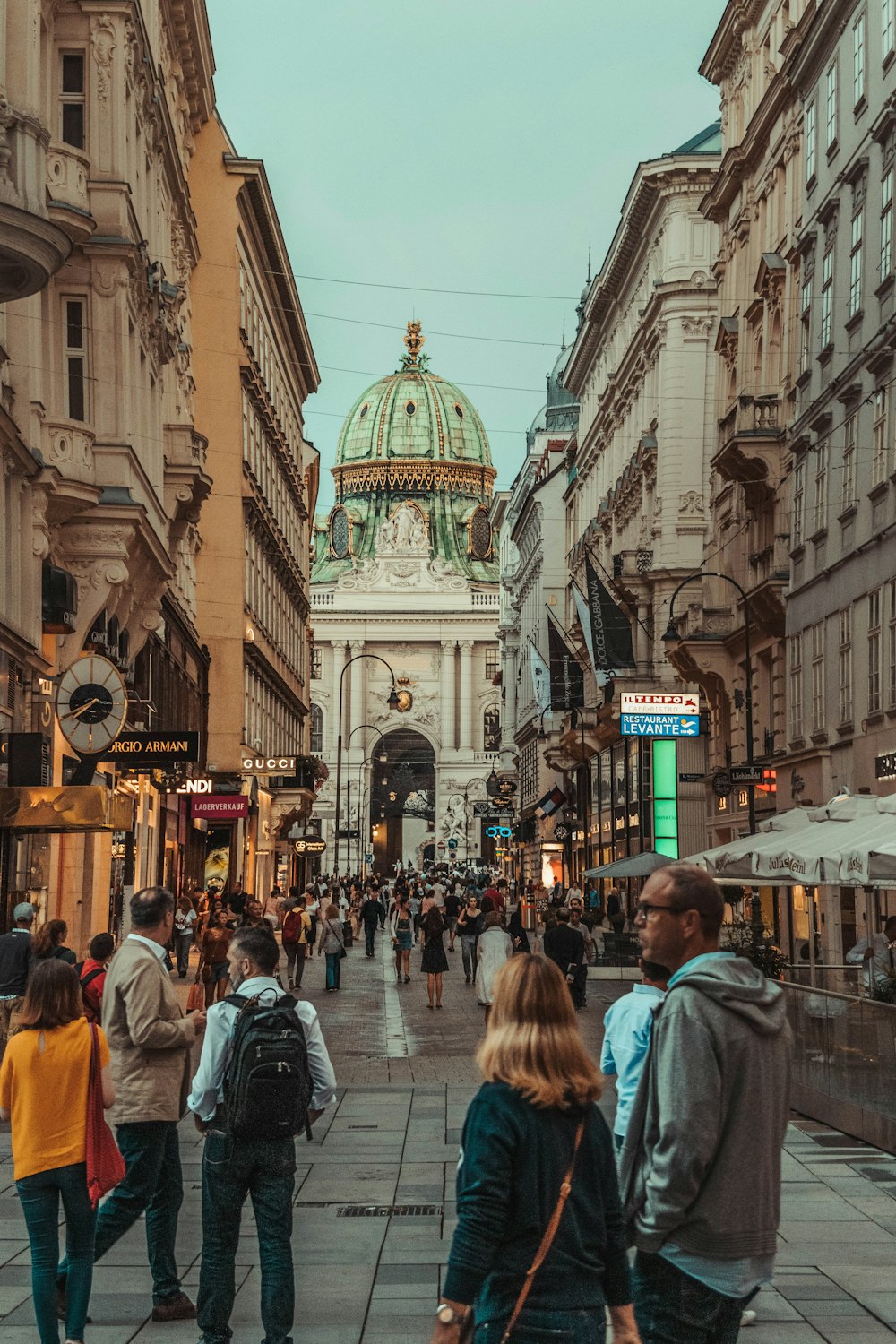 people walking between two buildings during daytime