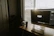 A happy customer sitting at a modern wooden desk with a laptop and a cup of coffee, sunlight streaming through a nearby window.