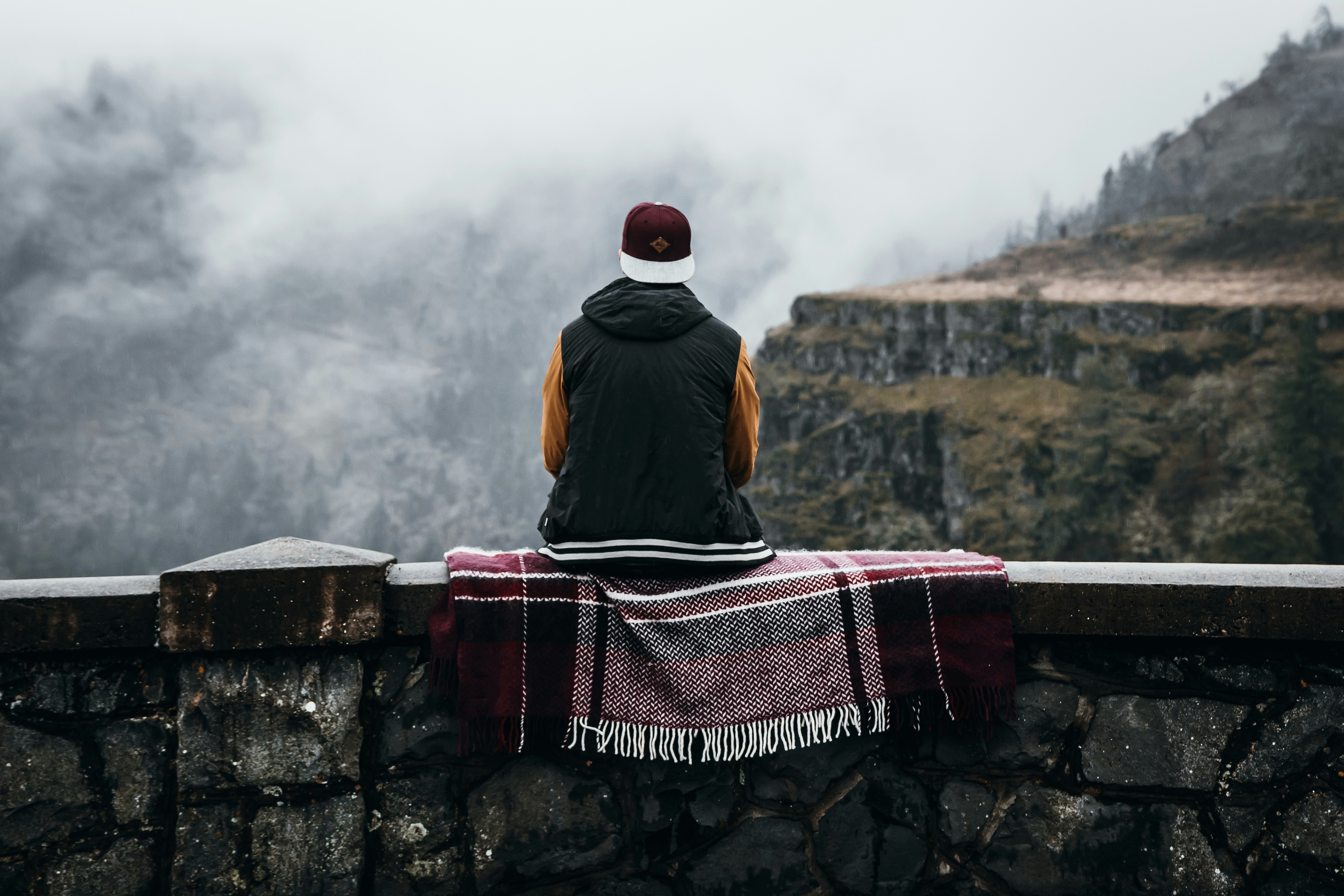 Mann sitzt tagsüber auf Betonbank