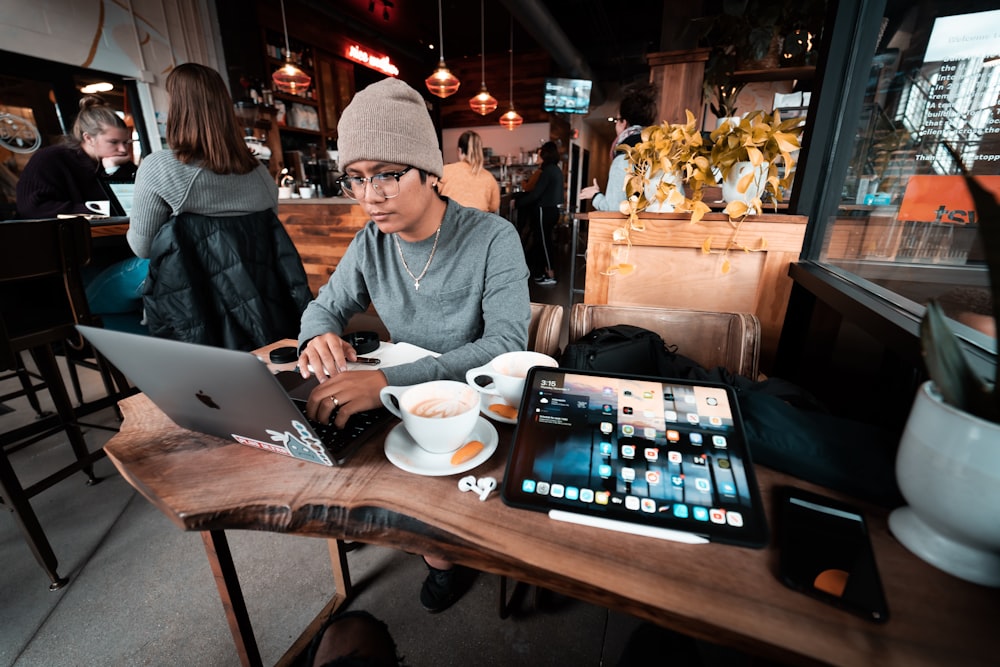 a man sitting at a table working on a laptop