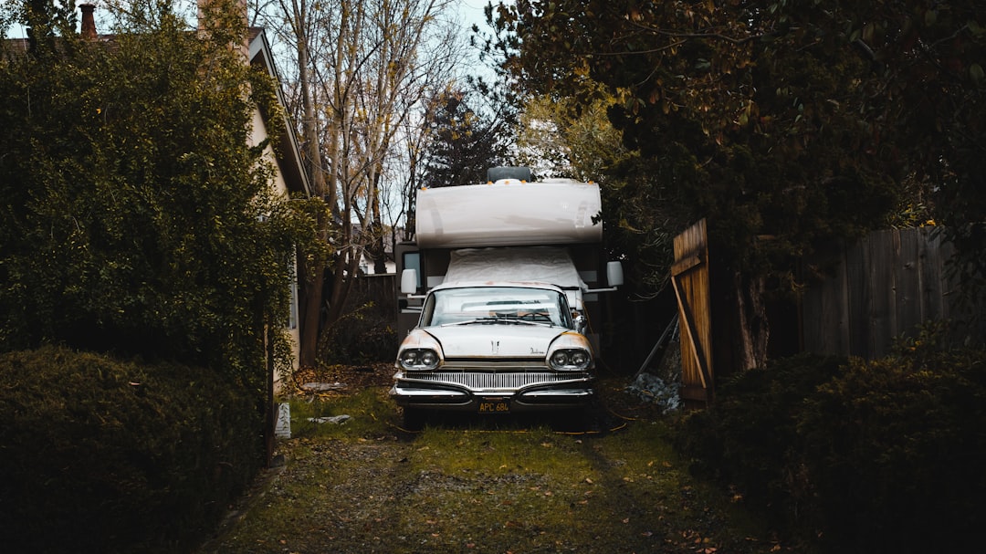 parked white camper trailer beside gate