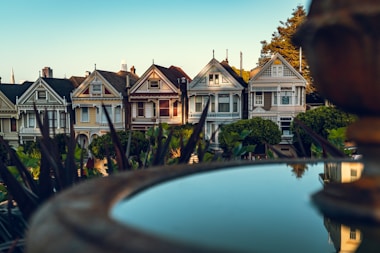 selective focus photography of water fountain near white concrete houses