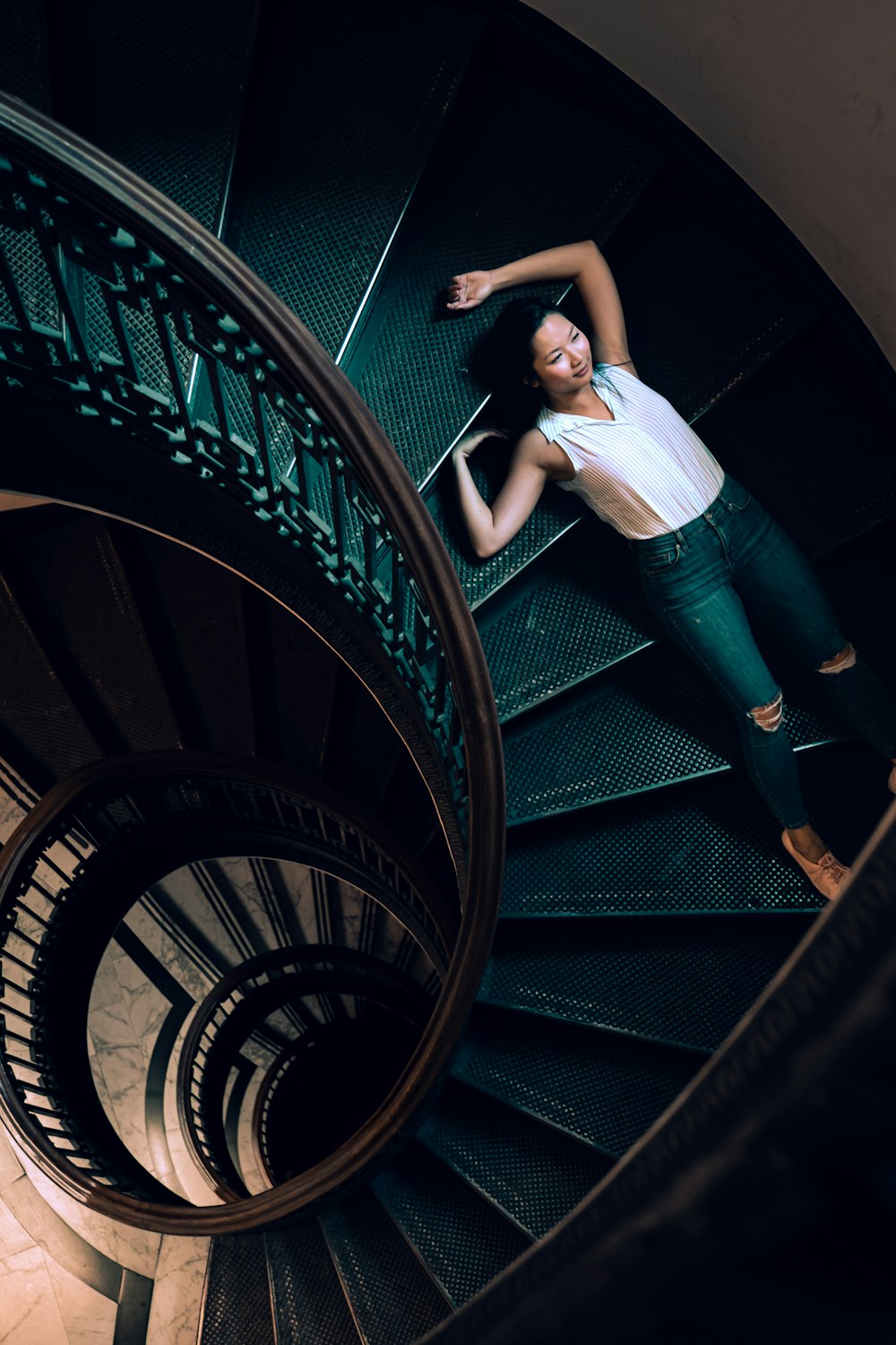 woman lying on gray stairs inside building