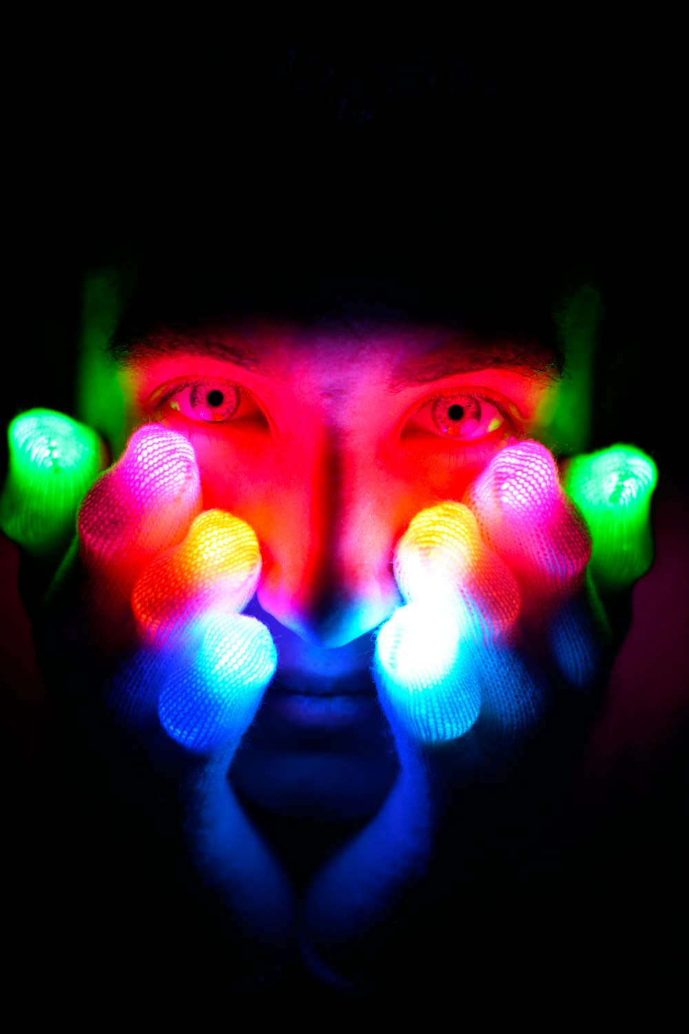 a man with his hands on his face with lights in the dark