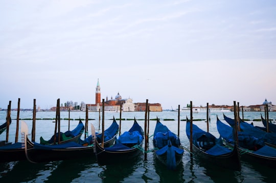 boat on sea near red lighthouse during daytime in Church of San Giorgio Maggiore Italy