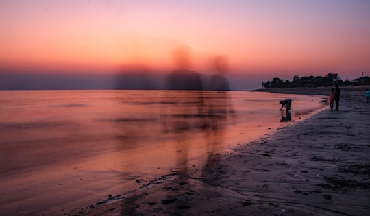 silhouette of two person on seashore in Bakkhali India