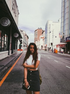 A stylish young Asian professional woman confidently using a smartphone in a modern urban setting.